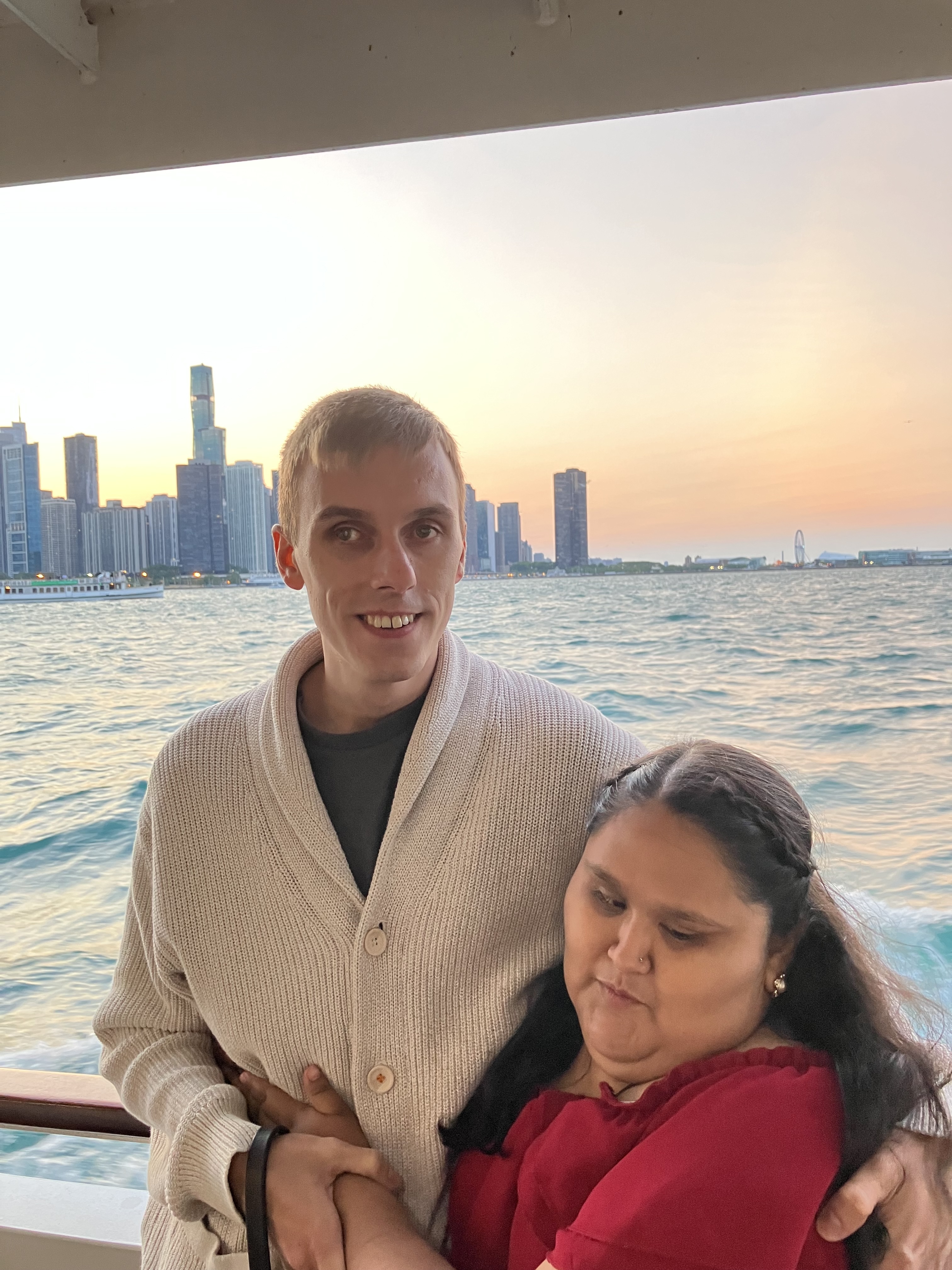 Hunter and Daisy on a boat on Lake Michigan at sunset, the Chicago skyline behind them